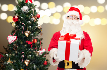 santa claus with gift box at christmas tree
