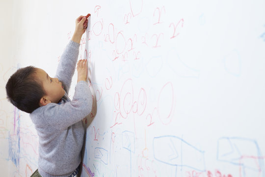 Little Boy Drawing Picture On The Wall