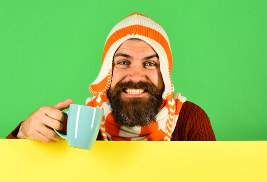 Hipster with cheerful face has warm tea or coffee cup