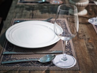 Luxury table set with wineglass, dish, spoon, fork and knife for romantic dinner.