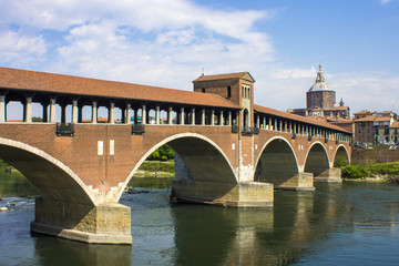 Fototapeta premium The Ponte Coperto (covered bridge), also known as the Ponte Vecchio (old bridge), a brick and stone arch bridge over the Ticino River in Pavia, Italy