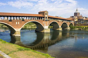 Fototapeta premium The Ponte Coperto (covered bridge), also known as the Ponte Vecchio (old bridge), a brick and stone arch bridge over the Ticino River in Pavia, Italy