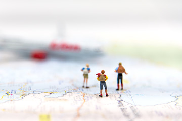 Obraz na płótnie Canvas Miniature Group traveler with backpack standing on wold map and walking to airplane on world map with copyspace for travel around the world. Travel Concept, select focus