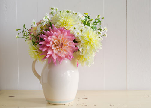 Dahlia and matricaria in an old fashioned ceramic pitcher.