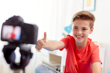 happy boy with camera recording video at home