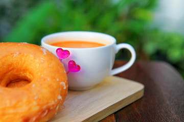 A cup of milk tea with donuts in the garden