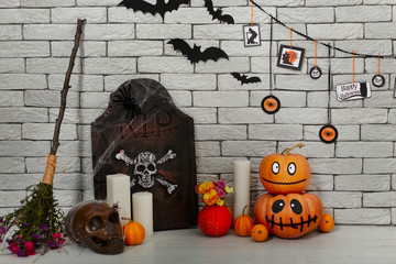 Halloween holiday decoration with tombstone, skull and pumpkins with funny face