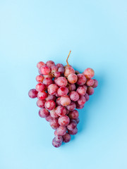 a grape of pink grapes isolated on a blue background