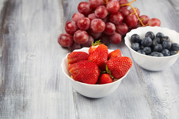 Berries and grapes on a gray wooden background