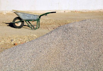 kieshaufen und schubkarre