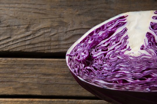 Halved purple cabbage on wooden table