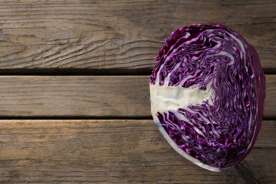 Halved purple cabbage on wooden table