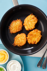 cooking pancakes in a non-stick frying pan on a blue background