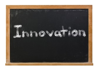 Innovation written in white chalk on a black chalkboard isolated on white