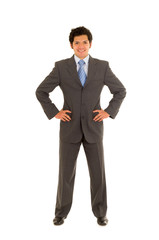 Full length of a handsome young man with curly hair, wearing a nice suit, and posing in a white background