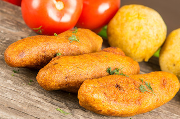 Muchin, an ecuadorian typical food with a blurred tomato and pepper, over a wooden table