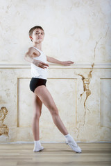 Little ballet caucasian boy dancing in a studio in white shirt and black underpants ballet uniform....