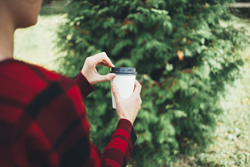 A young beautiful girl holds a cup of coffee in her hands