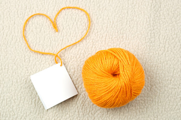 Wool ball and heart shape on white, wool background