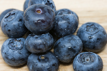 Close up of fresh Blueberries on wooden chopping board, sprayed with water.