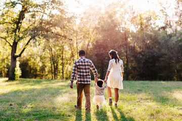An adorable family of three walking together in the park