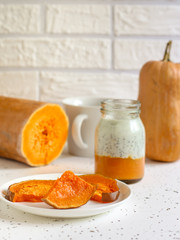 Baked gourd slices and yogurt with chili sienas on a light background