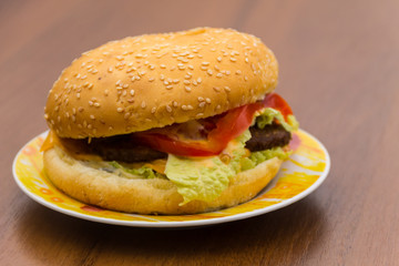 Delicious hamburger or sandwich on plate on wooden table