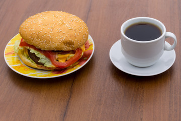 Delicious hamburger and cup of coffee on wooden table