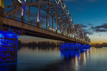 Obraz premium Illuminated railway bridge at twilight in Riga
