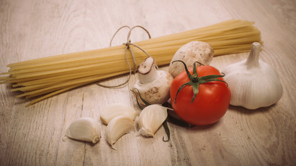 Food ingredients for preparing pasta on wooden kitchen board. Vegetables, sauces