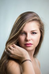 Fototapeta premium Young beautiful girl touching hair