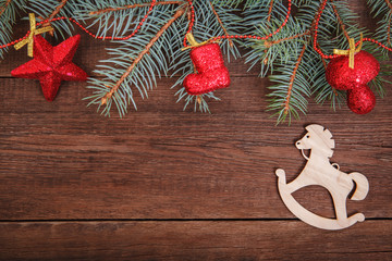 Christmas composition. Fir branches, red Christmas ornaments on a wooden brown background. Space for text, top view. Background