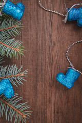 Christmas composition. Fir branches, blue Christmas decorations on a wooden brown background. Space for text, top view. Background