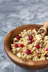 Granola muesli and cranberry berries for breakfast natural on a gray marble background with copy space, concept of a healthy diet