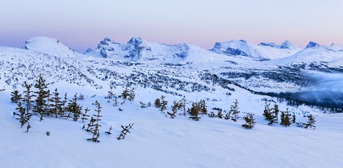 Winter Landscape Alpenglow over Distant Snowy Mountain Tops on Healy Pass after Banff National Park...