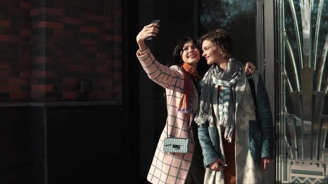 girlfriends make selfie on a mobile phone in the city.