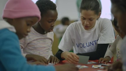 Charity worker playing with children from a poor African community - EDITORIAL