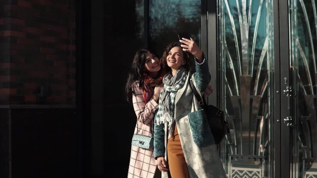 girlfriends make selfie on a mobile phone in the city.