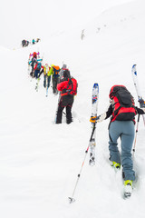 Group of cross-country skiers ascending a steep slope.