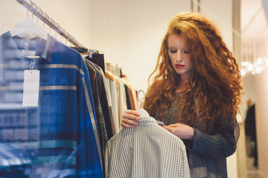 Young woman in a store checking the price on the label