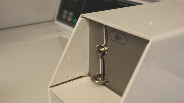 A woman putting money into a coin operated washing machine