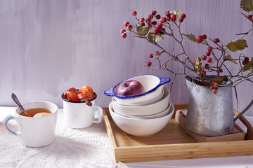 the Still-life with a hawthorn, a cup of tea and a kettle on a white wooden background