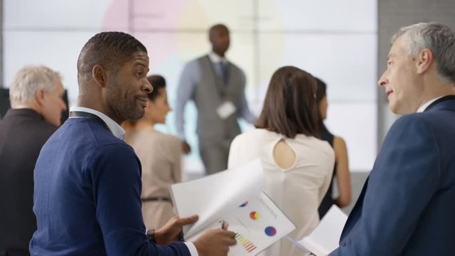  Businessmen discussing information they have learned at business seminar