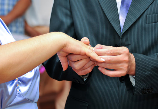The hands of the newlyweds are close-ups. Wedding