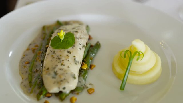 Close up on fish dish in gourmet restaurant, unrecognizable diner eating