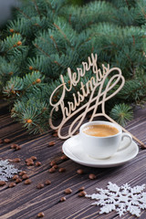 The cup of coffee stands on a wooden table. Congratulation Merry Christmas.