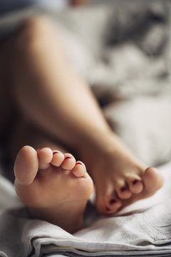 Feet of a Woman Sitting in Bed