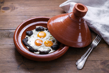Close view of fried egg and beef in tajine dish, traditional Moroccan dish