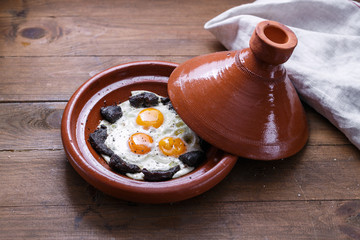 Close view of fried egg and beef in tajine dish, traditional Moroccan dish