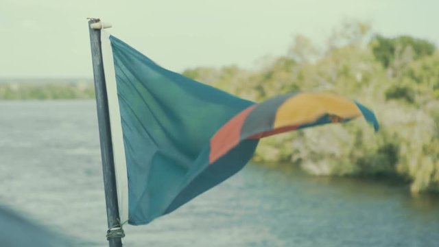  Zambia flag flying in the wind, attached to a boat sailing on Zambezi river
